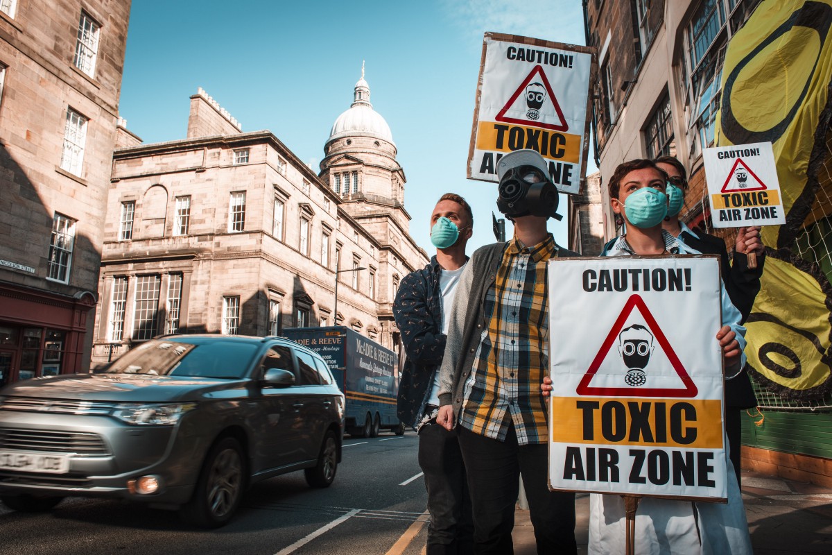 A group of protesters stand beside a road in Edinburgh.